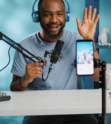 African american vlogger using smartphone to film podcast