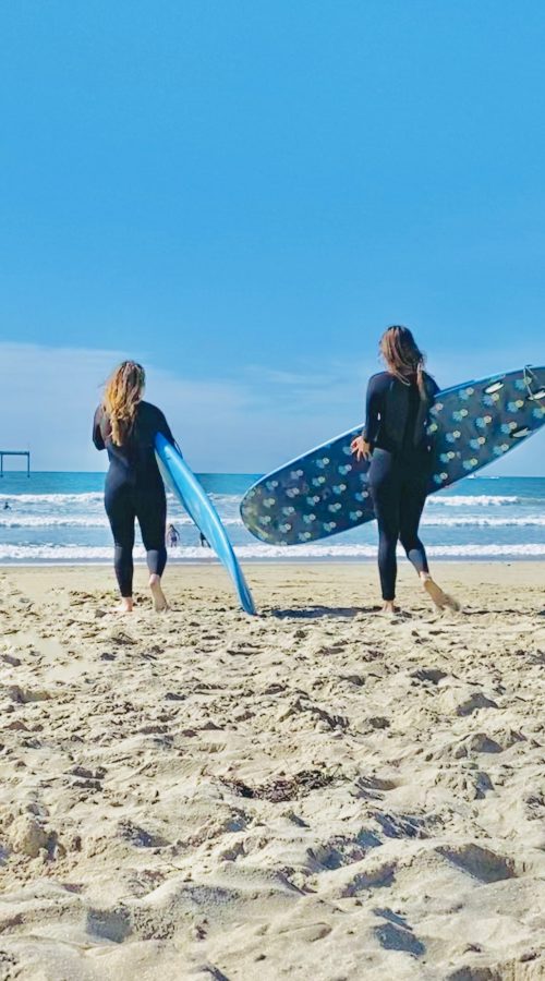 Surfer girls in the beach with their surfboards